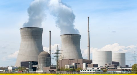 What are the costs of building, operating, and decommissioning a nuclear power plant versus the profit from selling the electricity and heat produced?